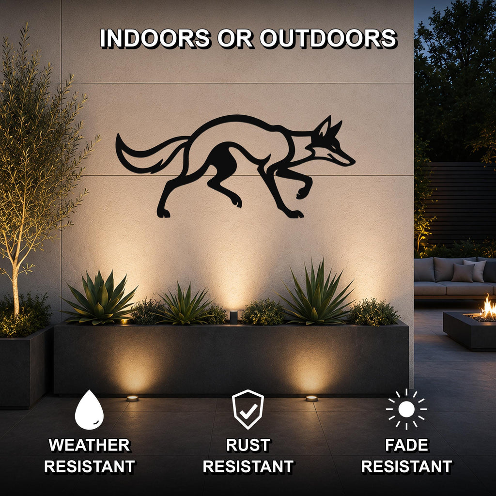 Black metal coyote wall art silhouette mounted on an outdoor wall above a planter, with integrated lighting and visible weather, rust, and fade resistance features.