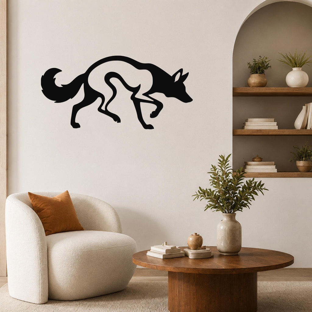 Black metal coyote wall art with a silhouette design, mounted on a living room wall above a round wooden coffee table.