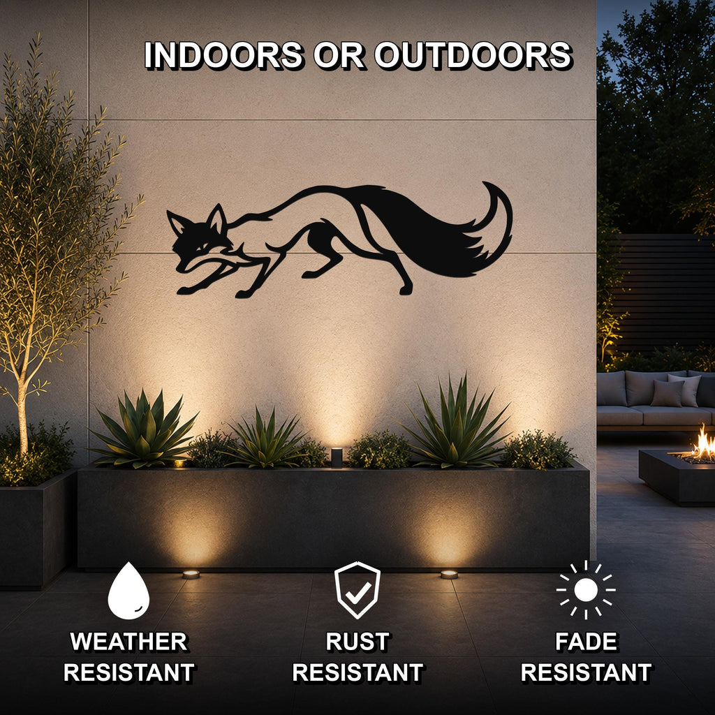 Black metal fox wall art silhouette with motion-line cutouts, mounted on an outdoor wall above a planter in a modern patio setting.