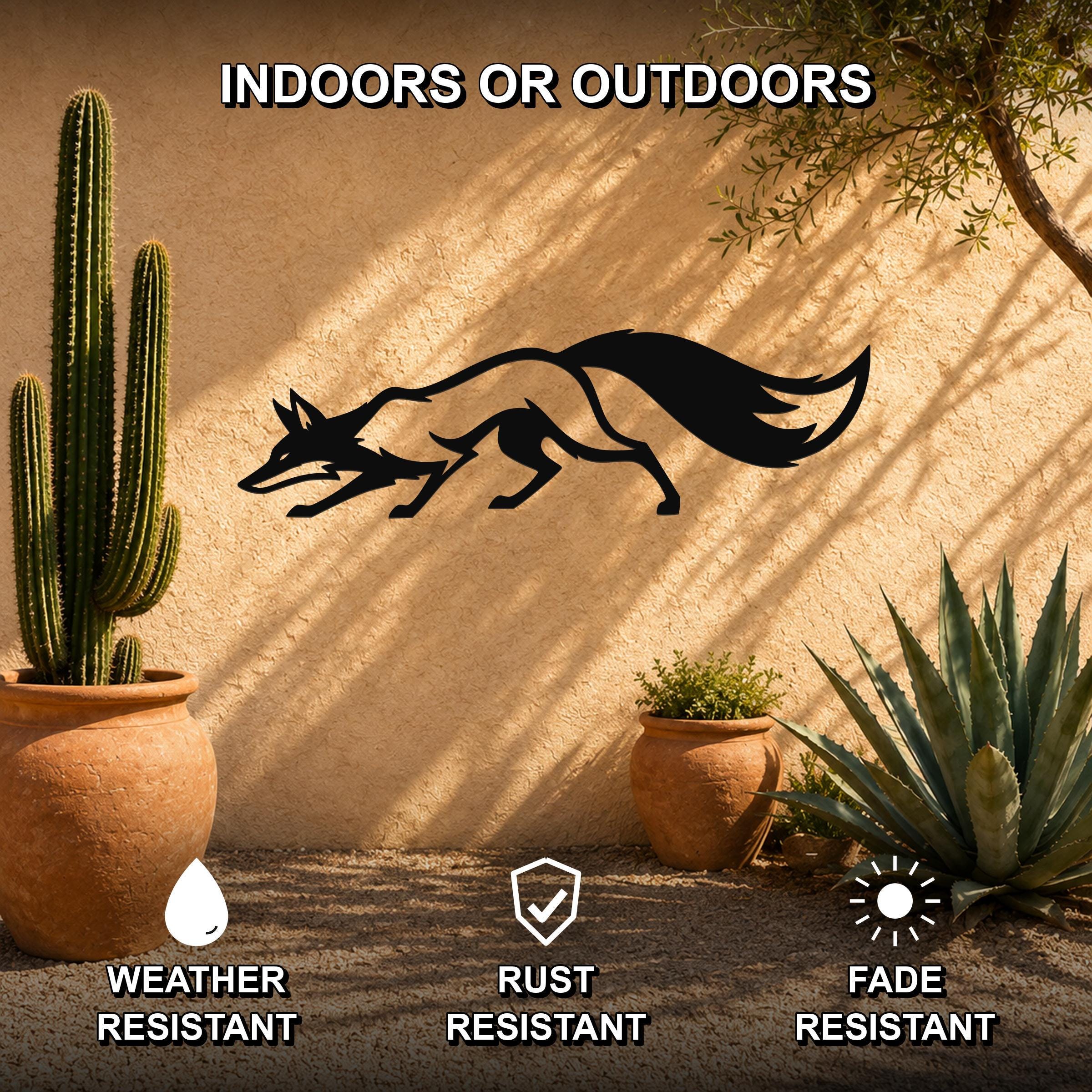 Black metal fox silhouette wall art mounted on a stucco outdoor wall, shown with potted cacti and succulents in a sunny patio setting.