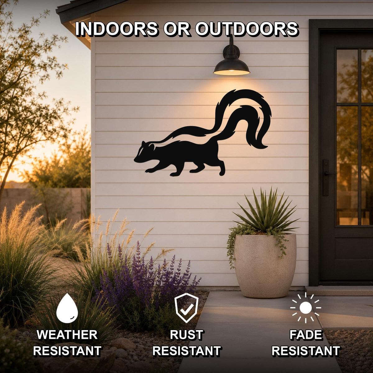 Black metal skunk silhouette wall art mounted on a white siding exterior wall above a patio, with a potted plant and garden in the foreground.