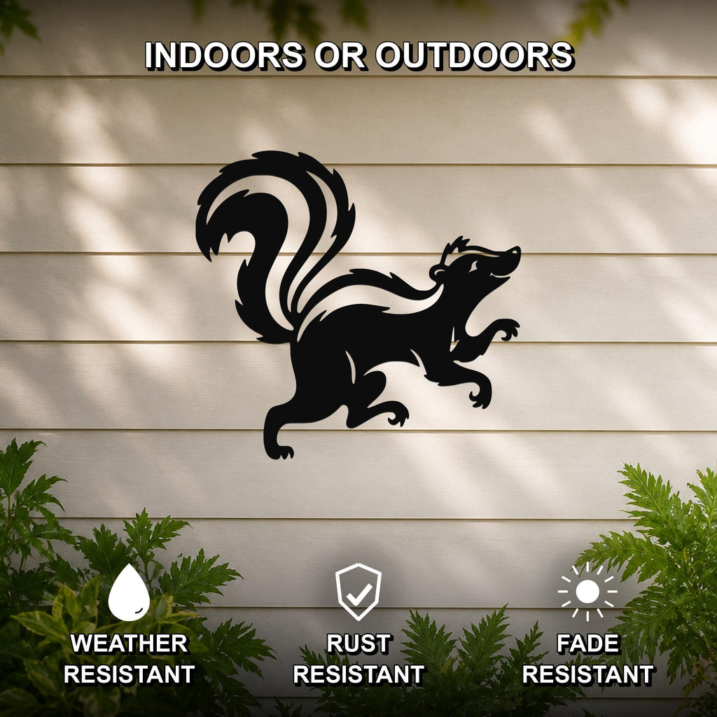 Black metal skunk wall art silhouette with a curved tail and raised front leg, mounted on a light-colored outdoor wall with greenery below.