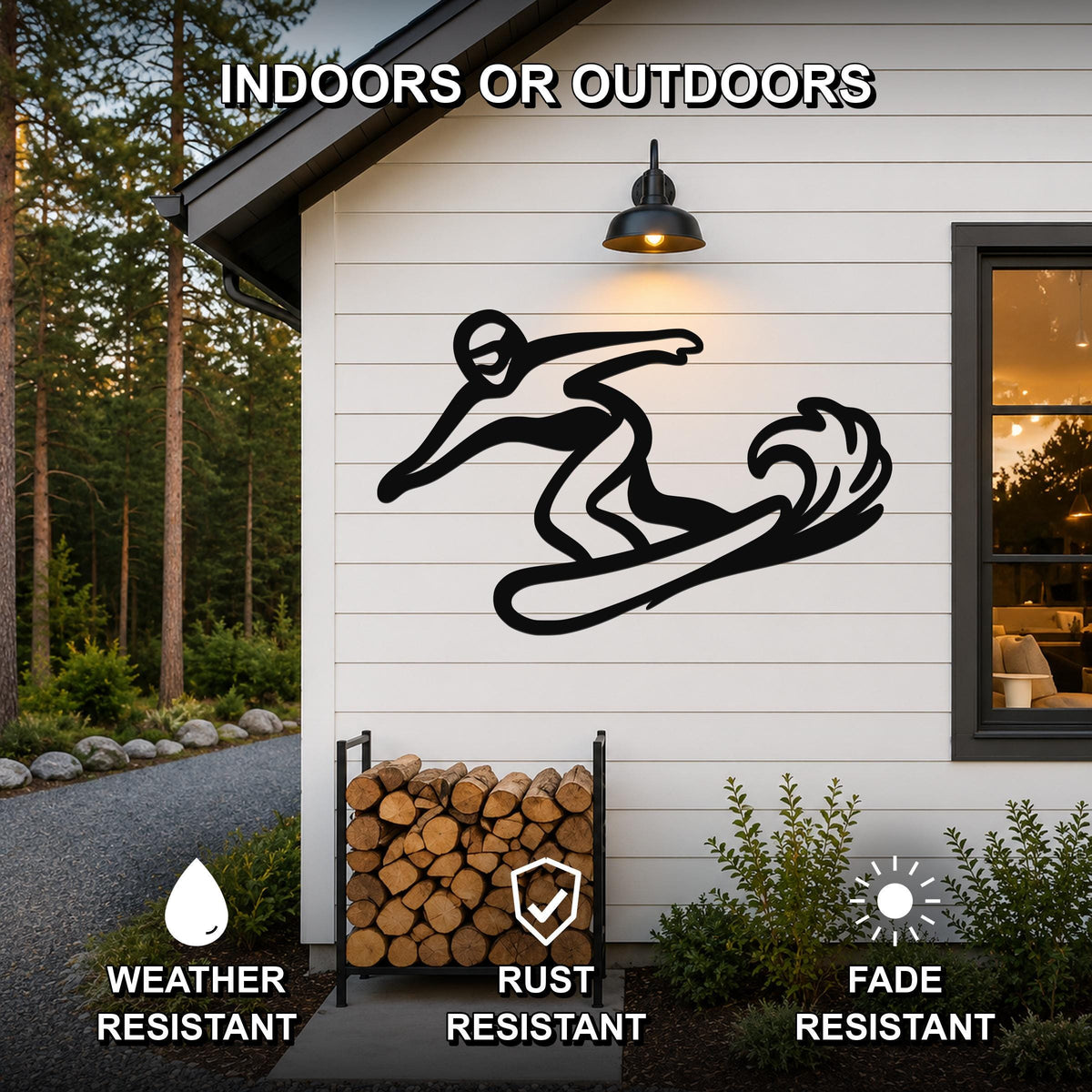 Black metal snowboarding wall art silhouette mounted on a white siding exterior wall above a firewood rack, with text indicating it is weather, rust, and fade resistant for indoor or outdoor use.