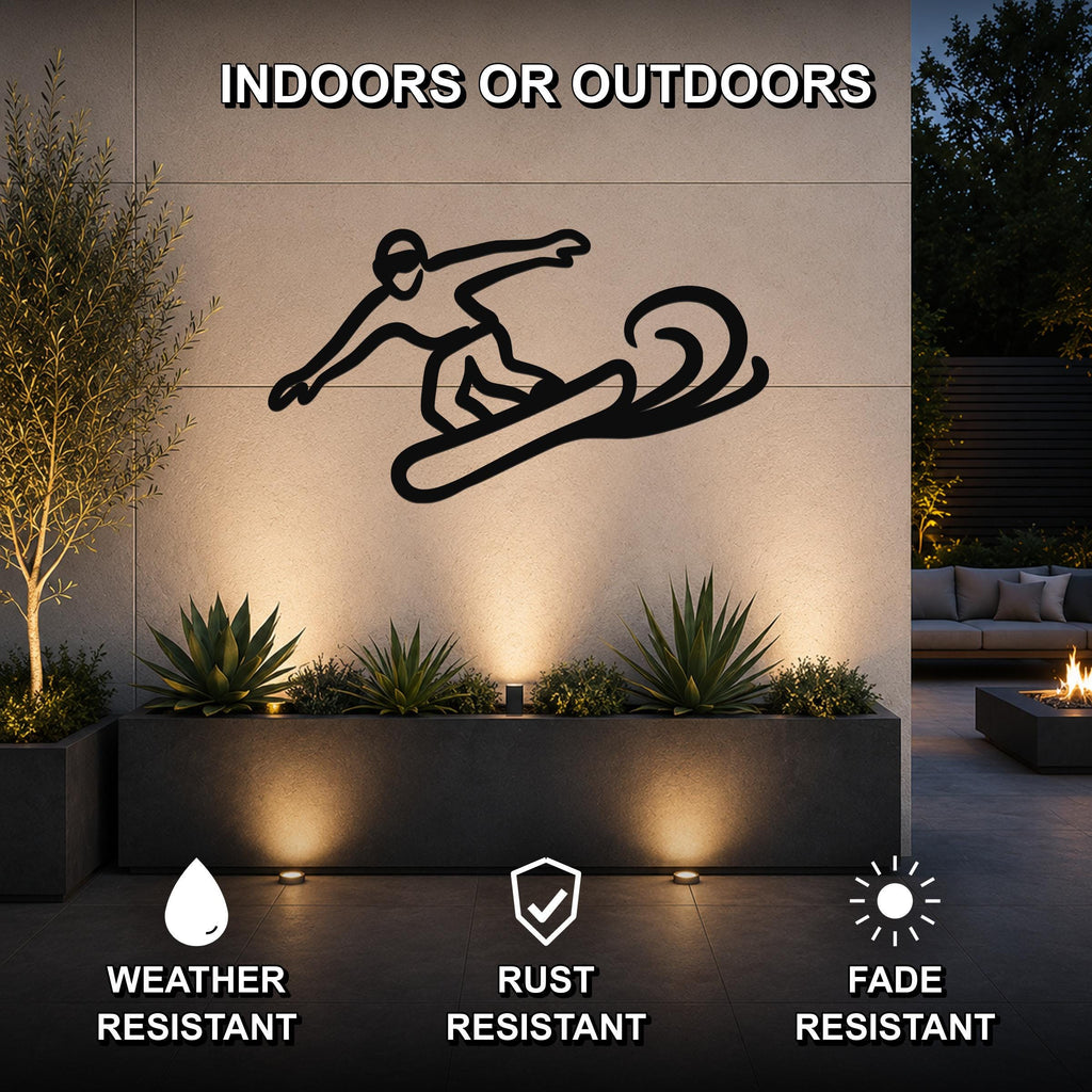 Black metal snowboarder silhouette wall art with motion lines, mounted on an outdoor wall above a planter in a patio setting.