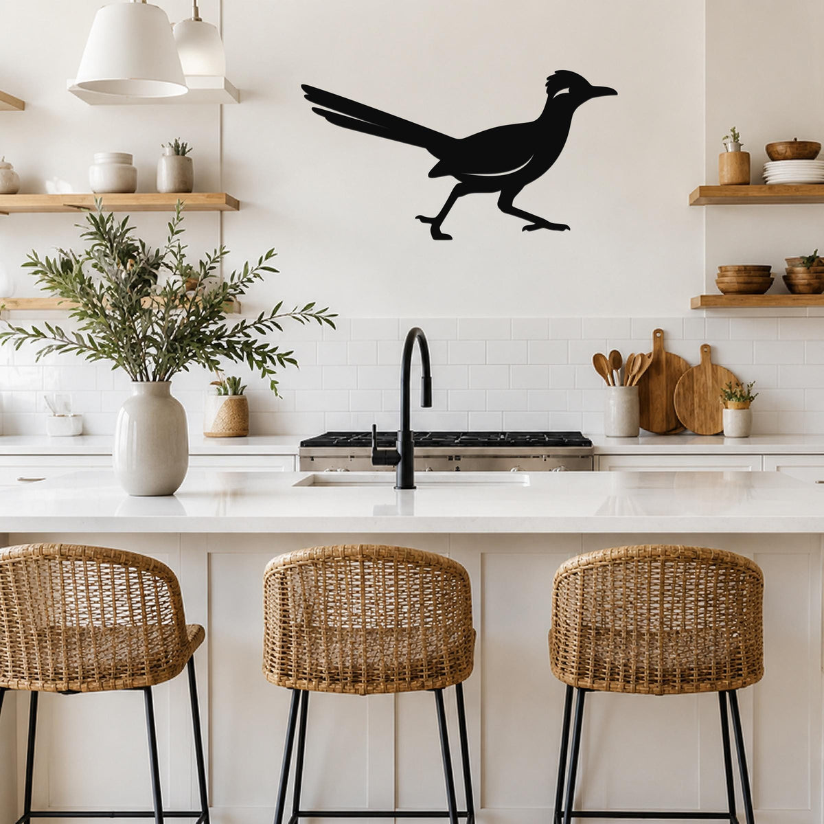 Black metal roadrunner wall sculpture with motion-line cutouts, mounted above a kitchen counter in a bright, modern kitchen.