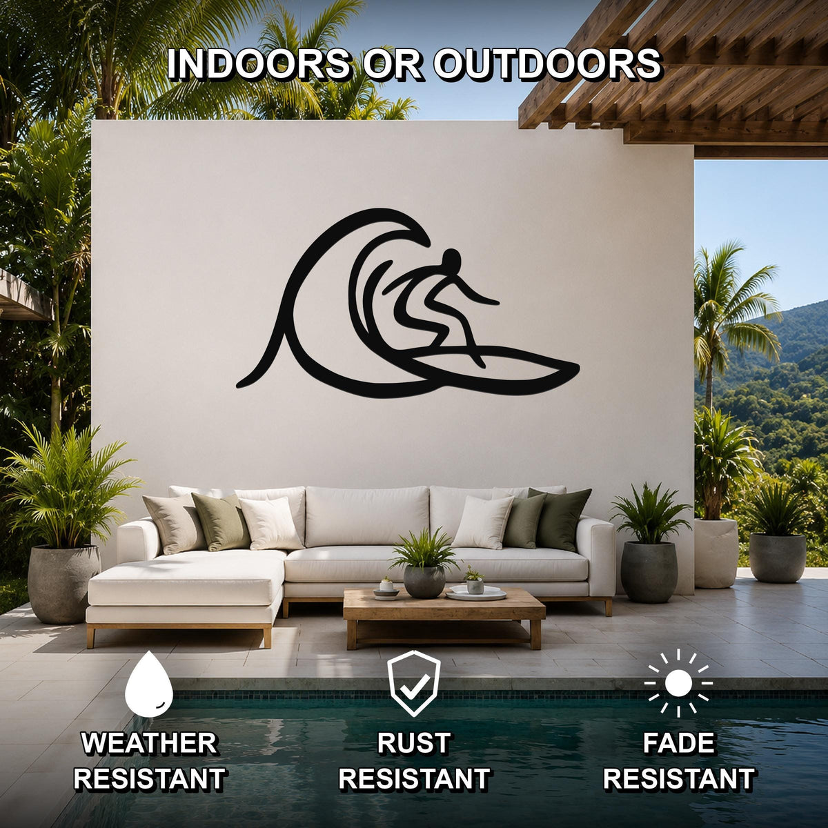Black metal surfer wall art with wave silhouette, mounted on a white outdoor patio wall above a sofa near a pool.