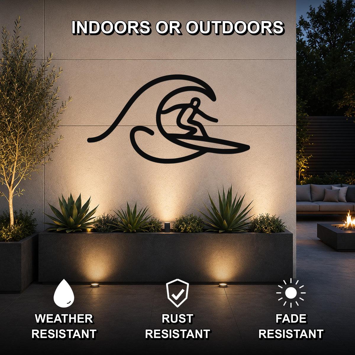 Black metal surfer wall art with a wave silhouette, mounted on an outdoor wall above a planter in a patio setting.