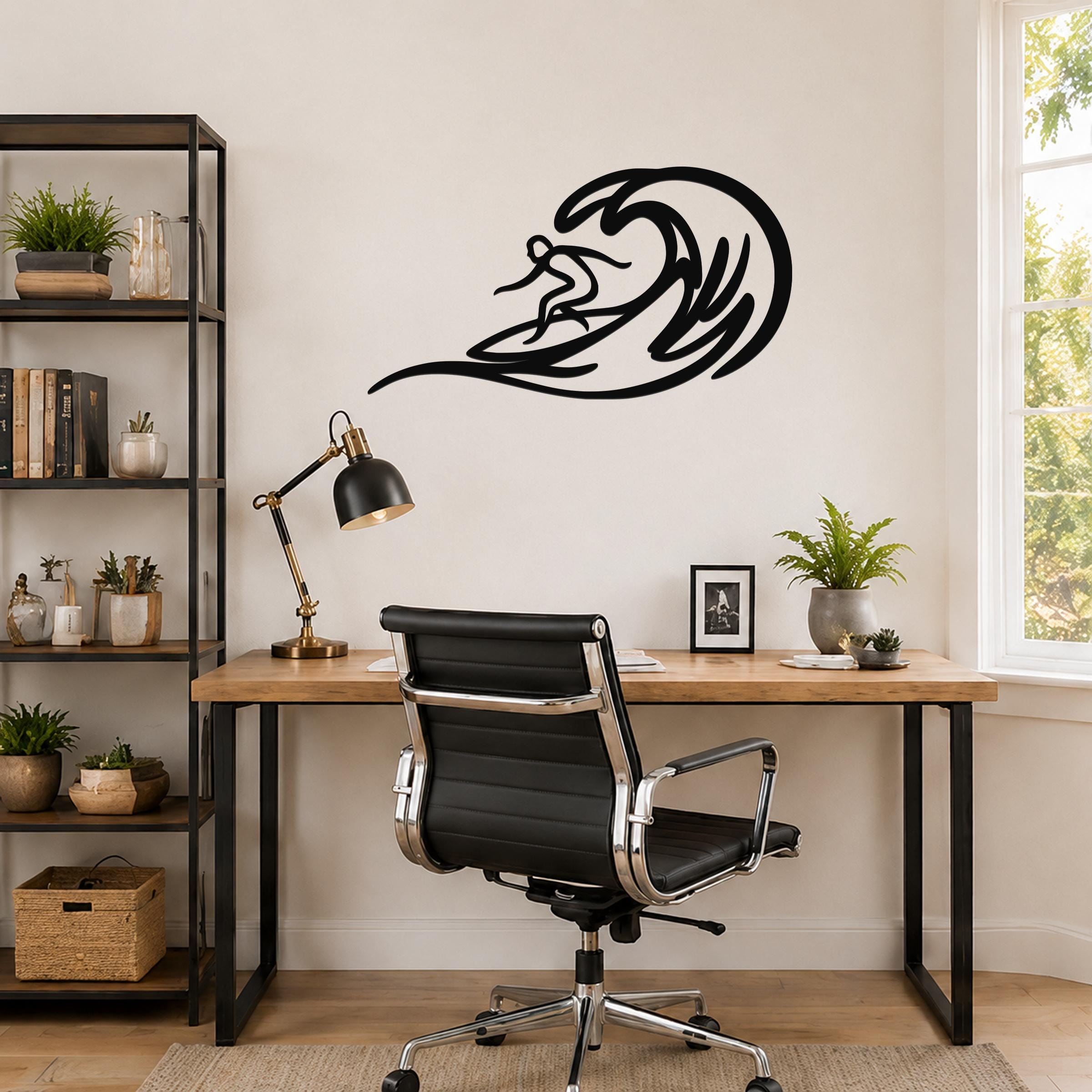 Black metal surfer wall art with wave cutout design, mounted above a wooden desk in a home office.