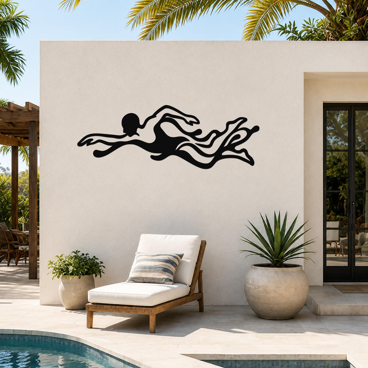 Black metal swimmer wall art with flowing motion cutouts, mounted on an outdoor patio wall above a lounge chair.
