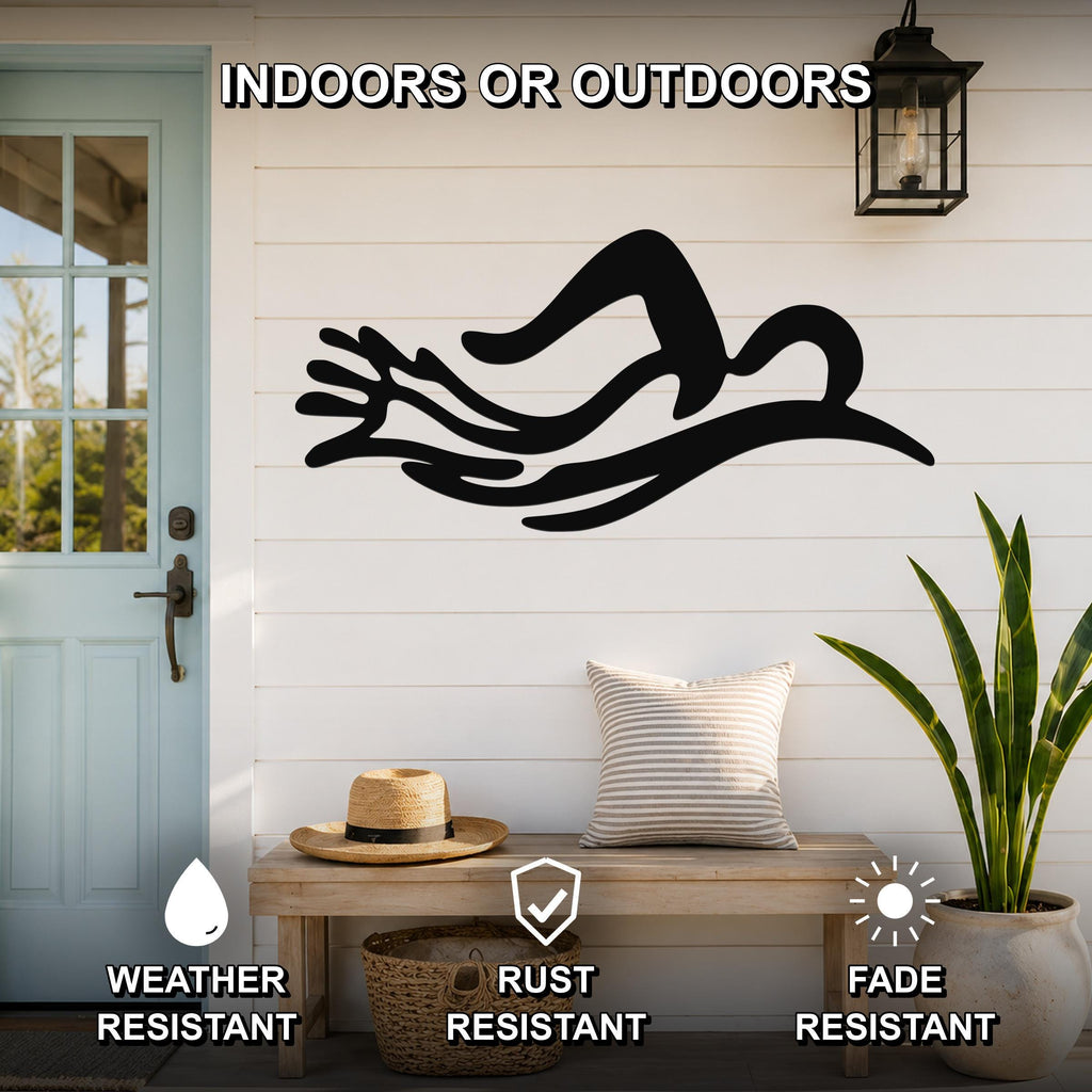Black metal wall art in the silhouette of a swimmer in motion, mounted on a white shiplap wall above a wooden bench on a porch.