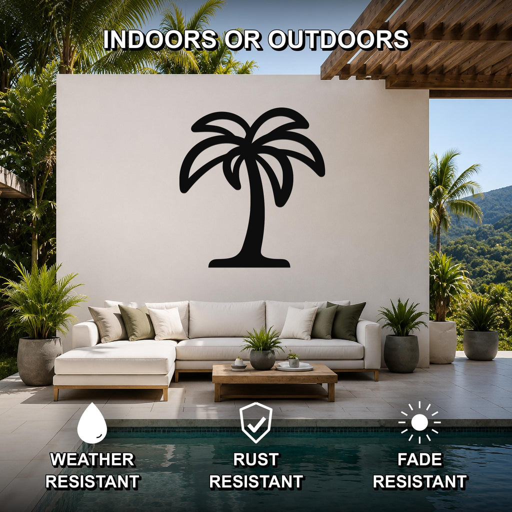Black metal palm tree wall art with a silhouette design, mounted on a white outdoor wall above a sofa in a patio living area.