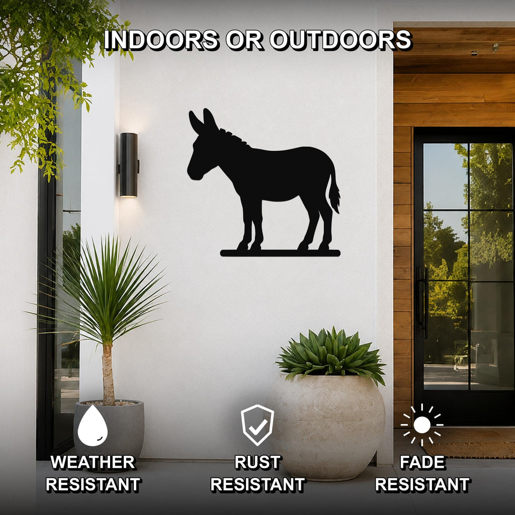 Black metal donkey silhouette wall art mounted on a white exterior wall beside a glass door and potted plants, with text indicating it is weather, rust, and fade resistant.
