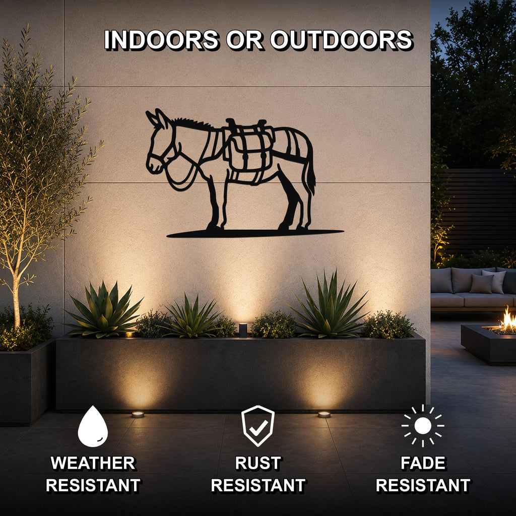 Black metal burro wall art with saddle cutouts, mounted on an outdoor wall above a planter in a patio setting.