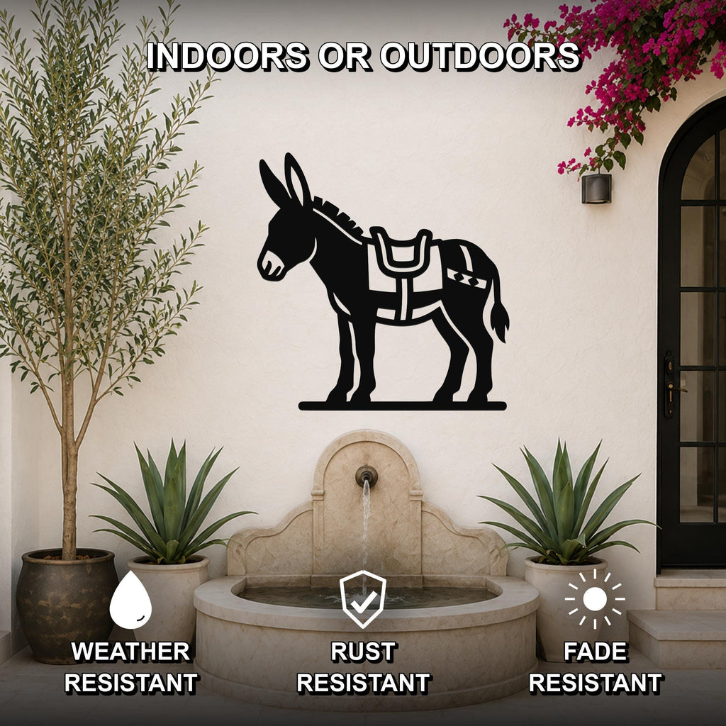 Black metal burro wall art with saddle cutout, mounted on an outdoor patio wall above a stone fountain.