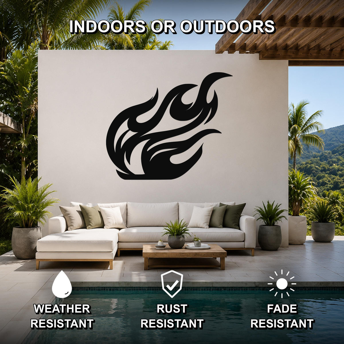 Black metal flame wall art with fluid silhouette cutouts, mounted on a white outdoor wall above a sofa in a patio living area.