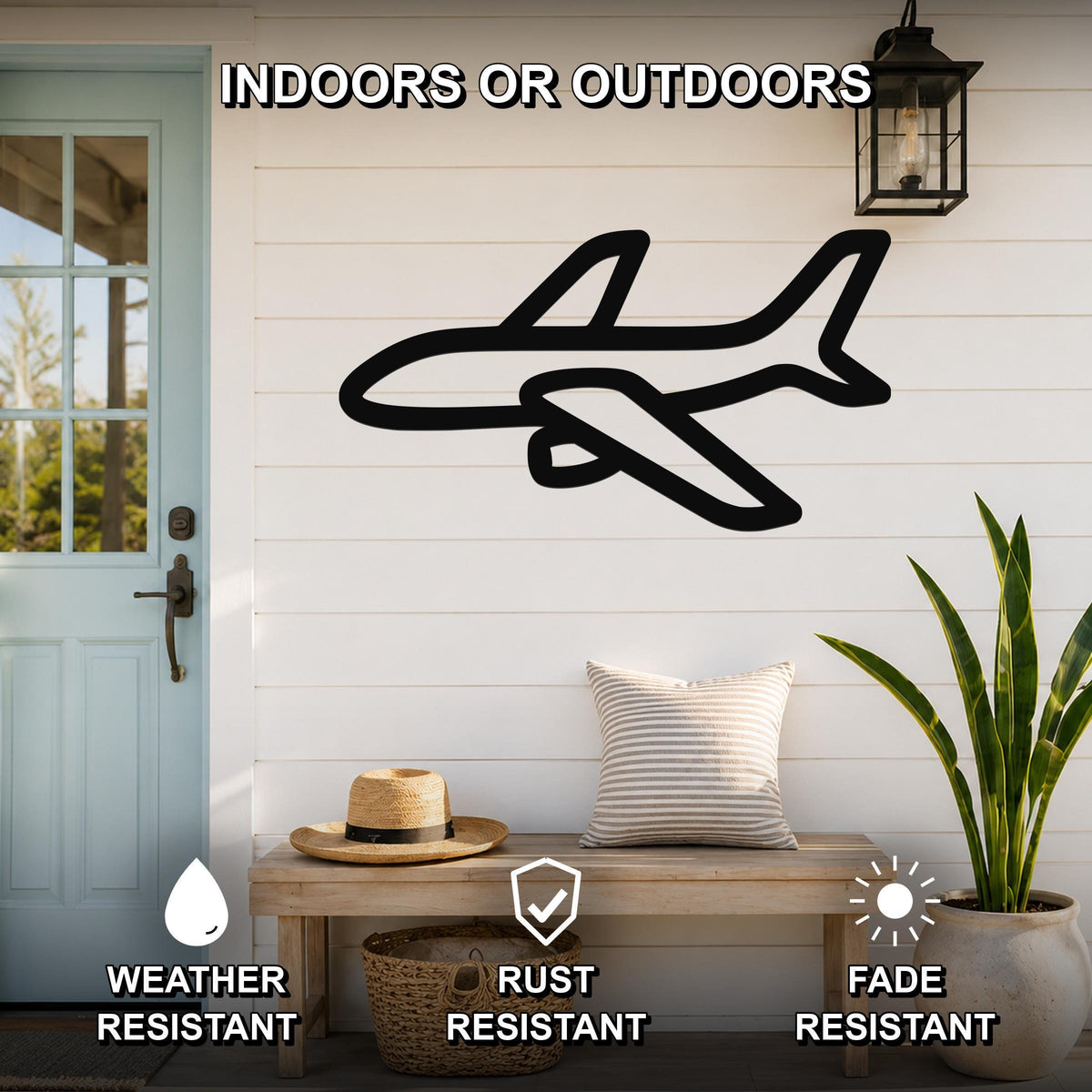 Black metal airplane silhouette wall art mounted on a white shiplap wall above a wooden bench on a porch, with weather, rust, and fade resistance icons.