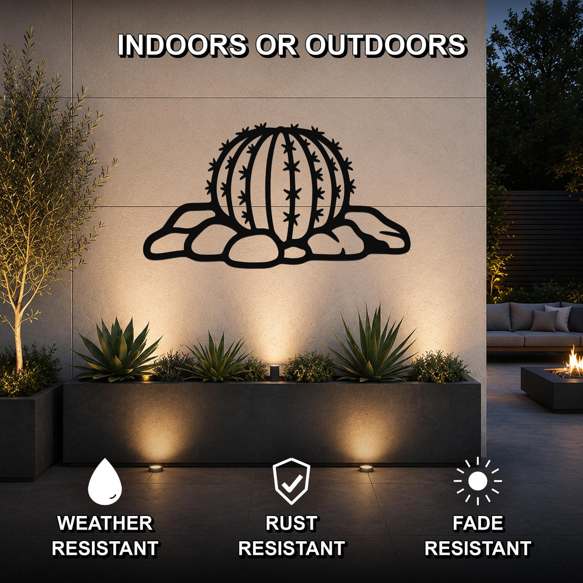 Black metal barrel cactus wall art with spines and rocks cutout, mounted on an outdoor wall above a planter in a modern patio setting.