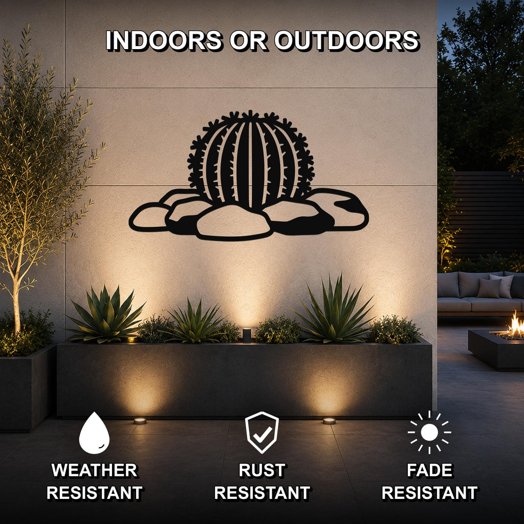 Black metal barrel cactus wall art with spines and rocks cutout, mounted on an outdoor wall above a planter in a patio setting.