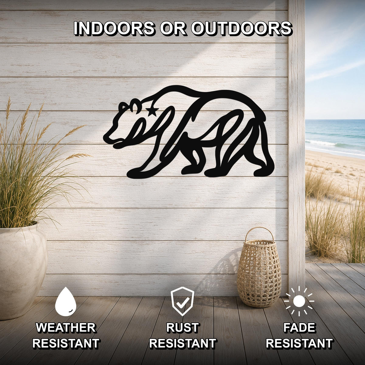 Black metal bear wall art with a star cutout, mounted on a light wood plank wall above a deck with a beach view.