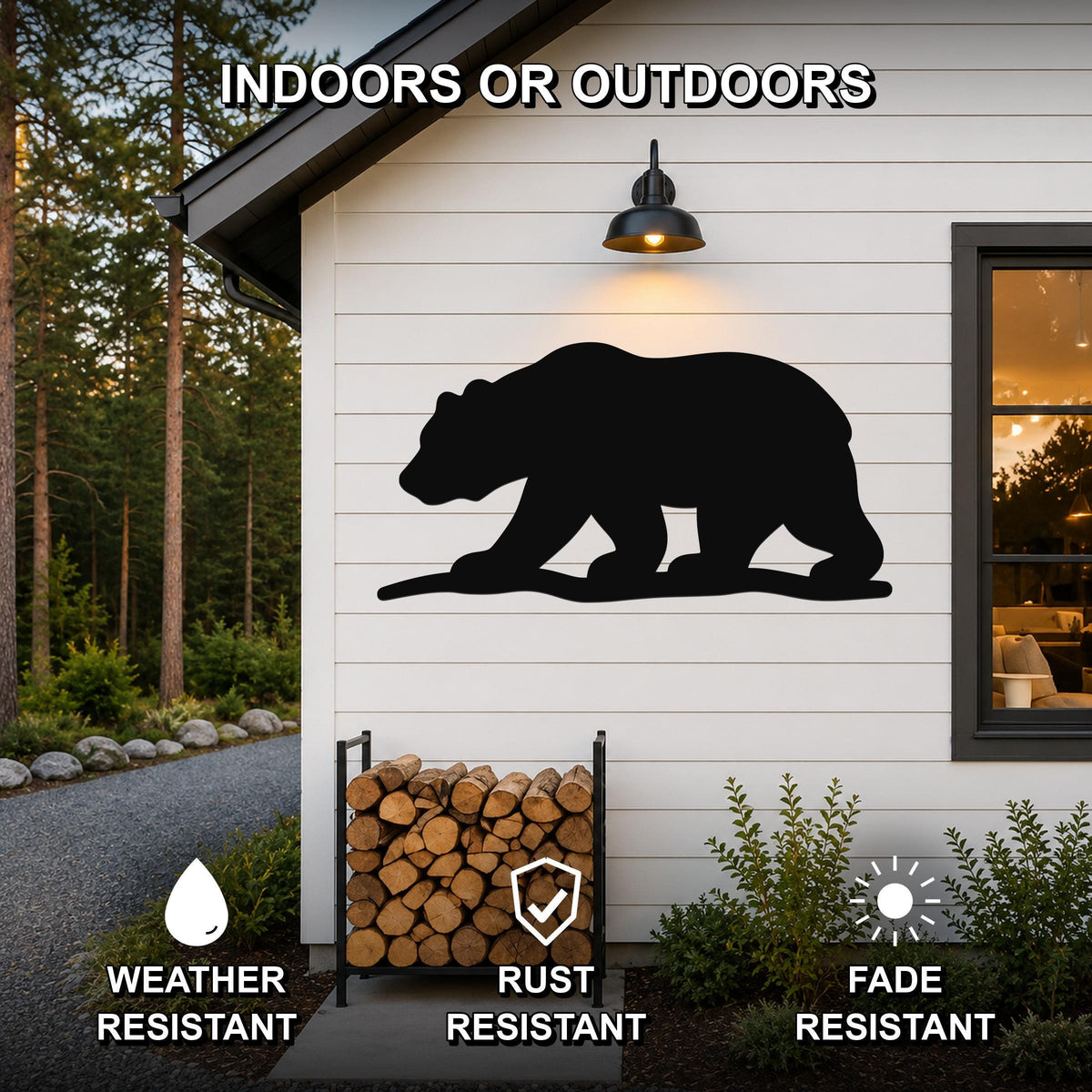 Black metal bear silhouette wall art mounted on a white siding exterior wall above a firewood rack, with text indicating it is weather, rust, and fade resistant for indoor or outdoor use.
