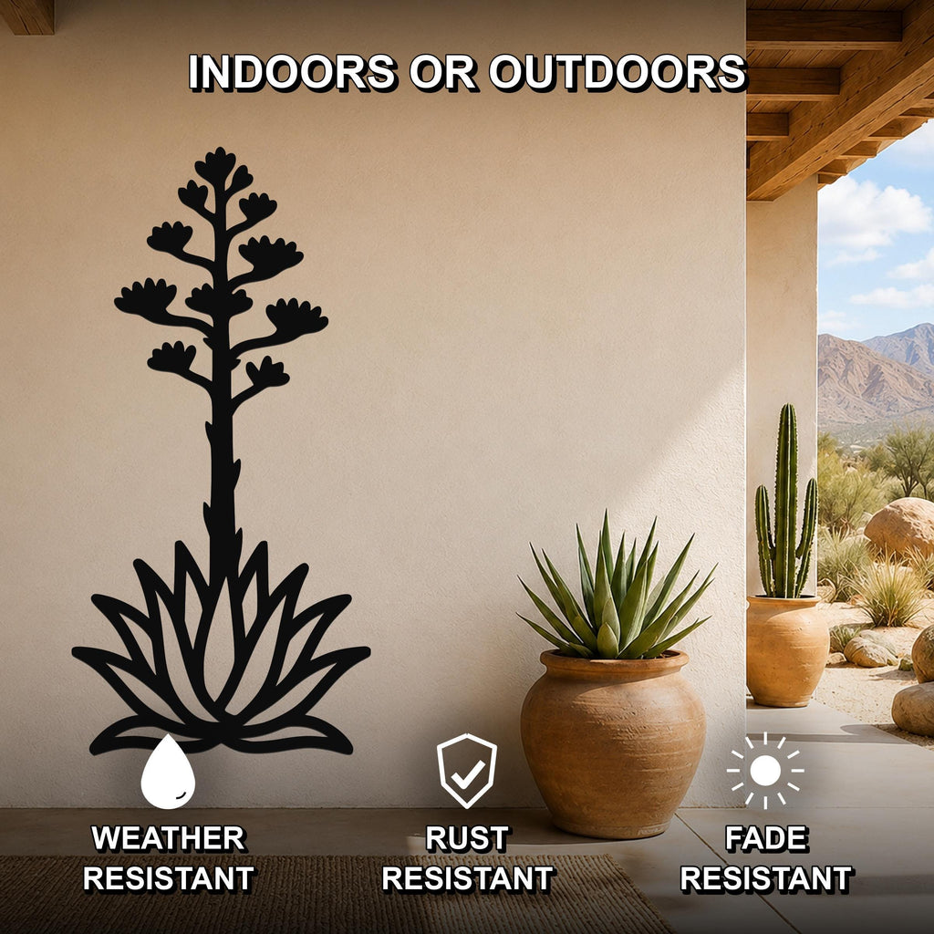 Black metal agave wall art with blooming flower cutout, mounted on a beige outdoor wall beside potted plants, weather resistant, rust resistant, fade resistant.