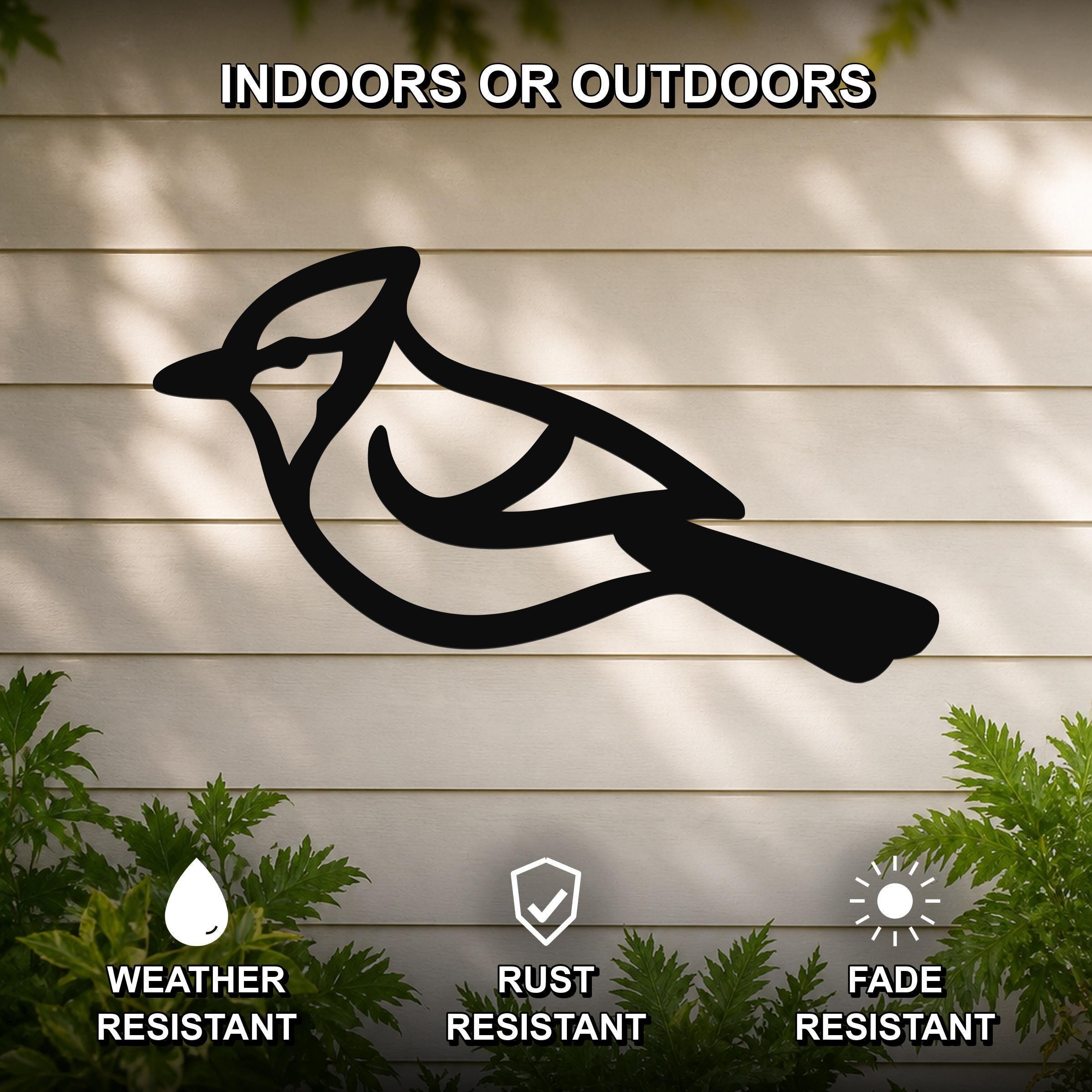 Black metal blue jay wall art silhouette mounted on a light-colored outdoor wall, with green foliage at the bottom and text indicating it is weather, rust, and fade resistant.