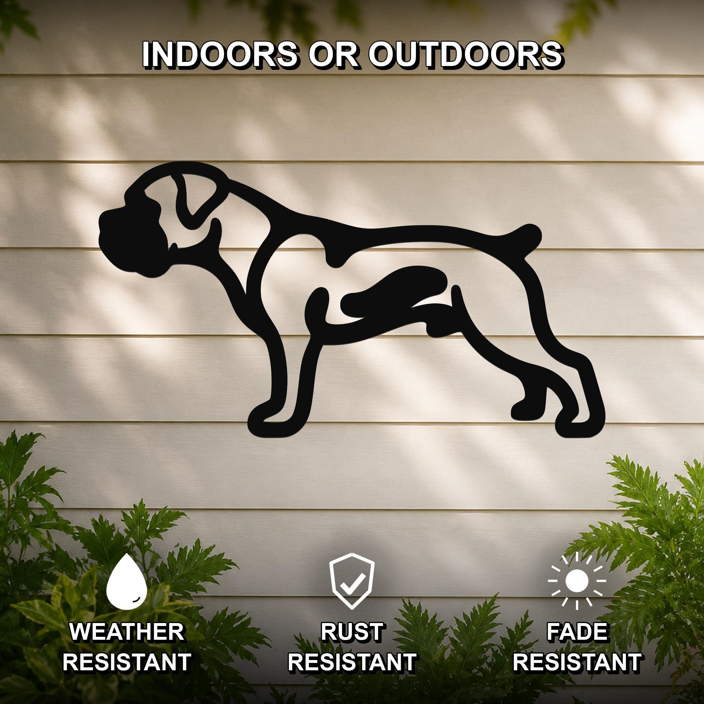Black metal Boxer dog silhouette wall art with internal cutout details, mounted on a light-colored outdoor wall with greenery, weather resistant, rust resistant, and fade resistant.