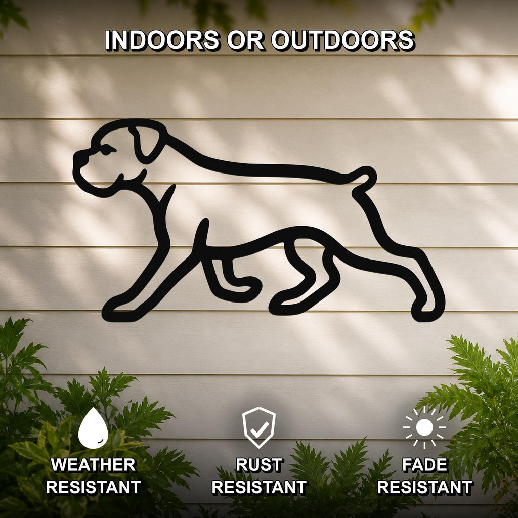Black metal Boxer dog silhouette wall art with bold outline, mounted on a light-colored outdoor wall with greenery, weather resistant, rust resistant, and fade resistant.