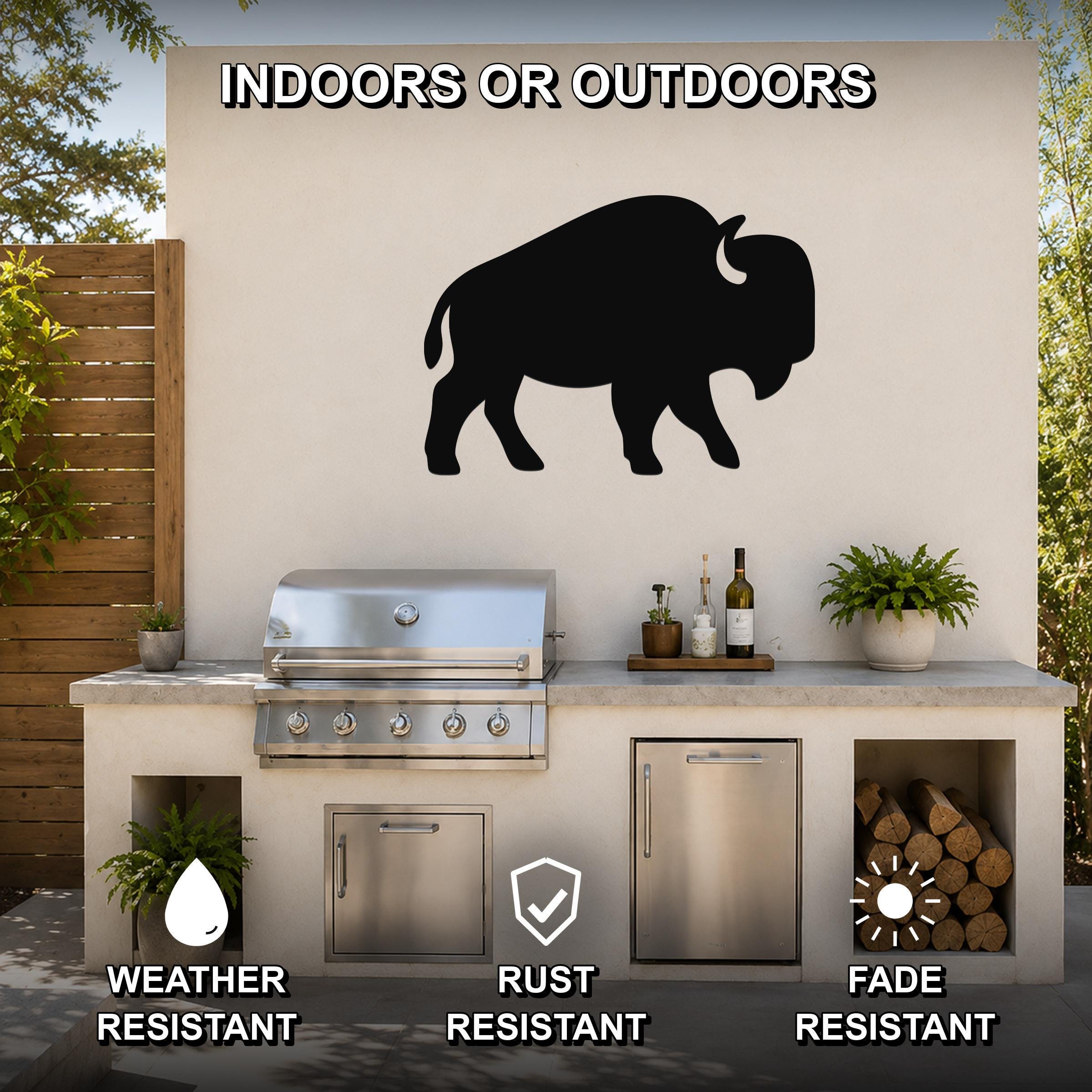 Black metal buffalo silhouette wall art mounted on an outdoor kitchen wall above a grill, with visible weather, rust, and fade resistance icons.