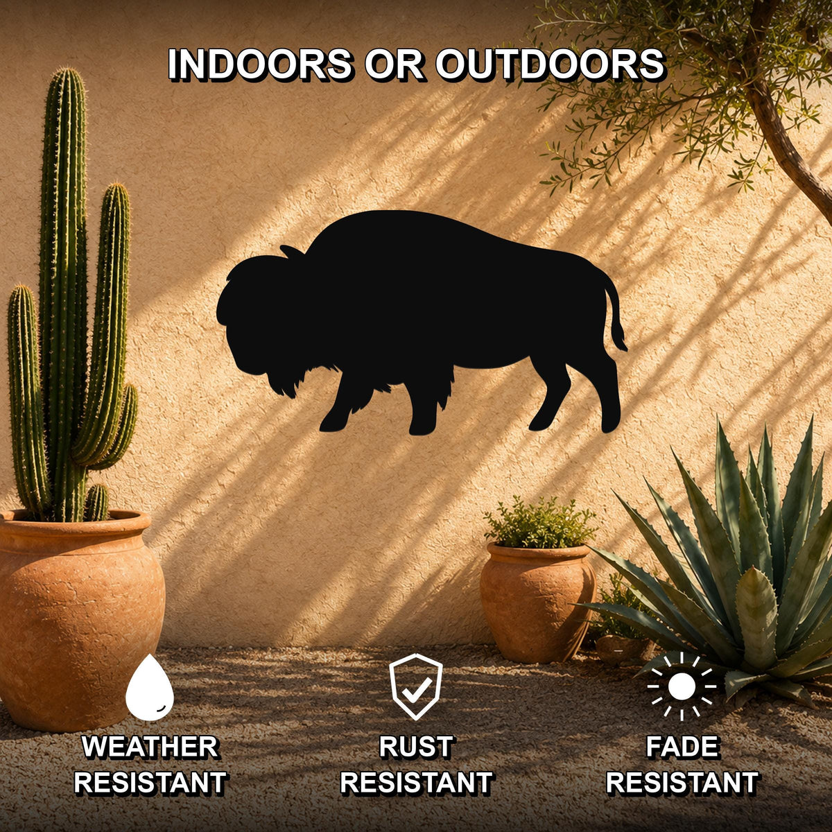 Black metal bison silhouette wall art mounted on a stucco outdoor wall, surrounded by potted cacti and succulents in a desert-style patio setting.
