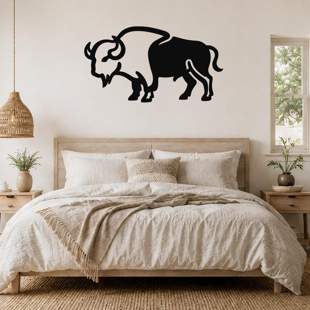 Black metal buffalo silhouette wall art mounted above a wooden bed in a neutral bedroom.