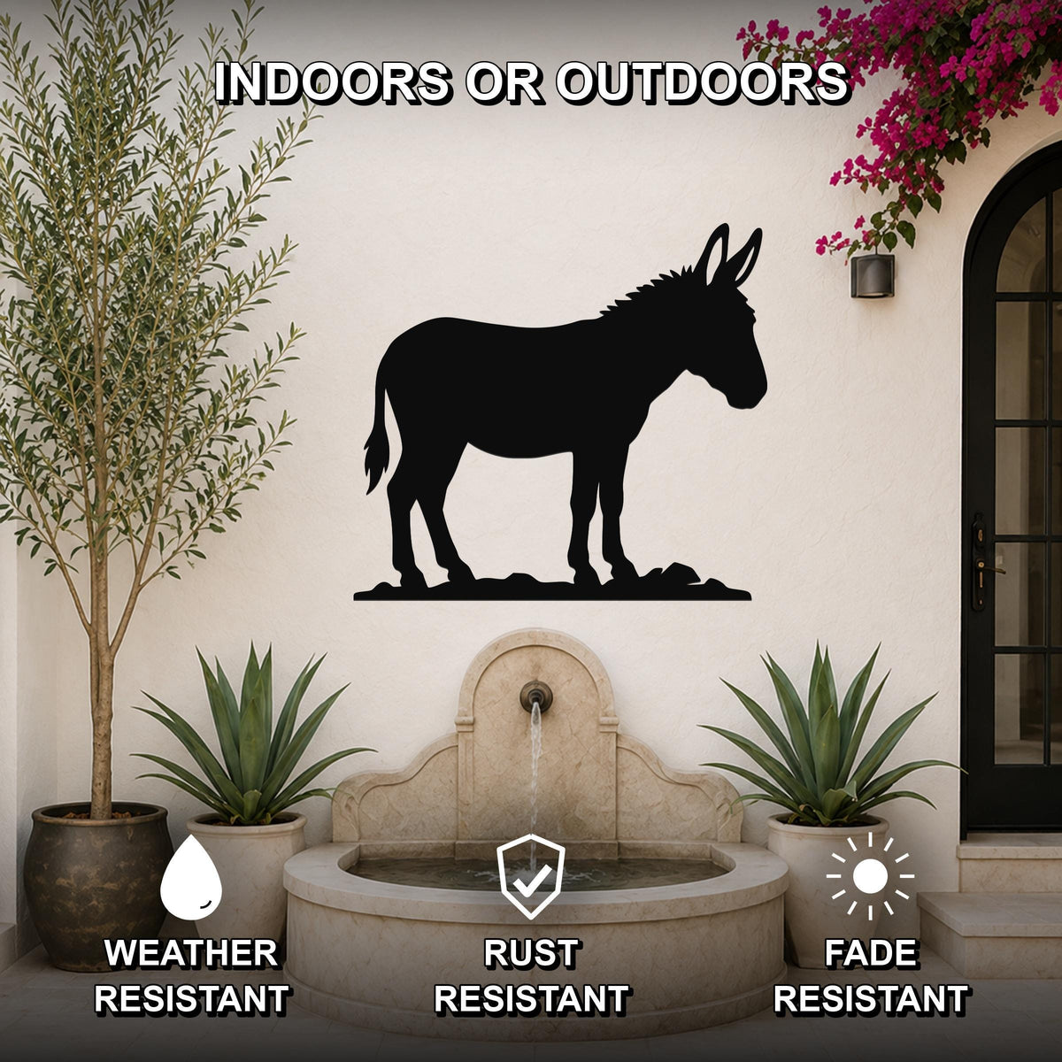 Black metal donkey silhouette wall art mounted on an outdoor patio wall above a stone fountain, flanked by potted plants and a flowering vine.