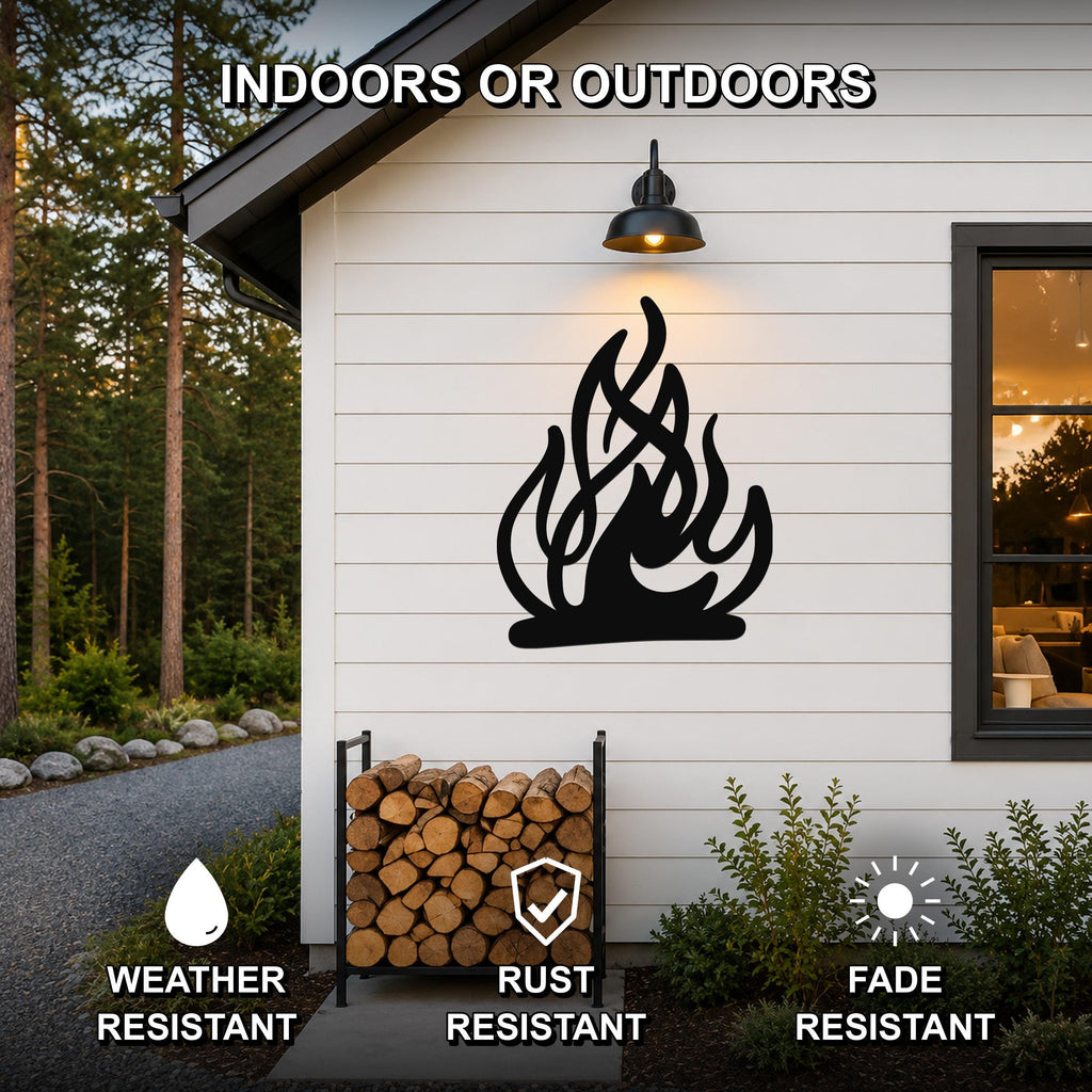 Black metal flame silhouette wall art mounted on a white siding exterior wall above a firewood rack, with text indicating it is weather, rust, and fade resistant for indoor or outdoor use.