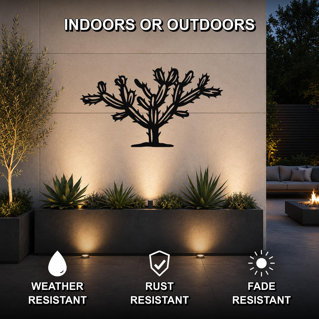 Black metal Cholla cactus wall art with detailed branch cutouts, mounted on an outdoor wall above a planter in a modern patio setting.