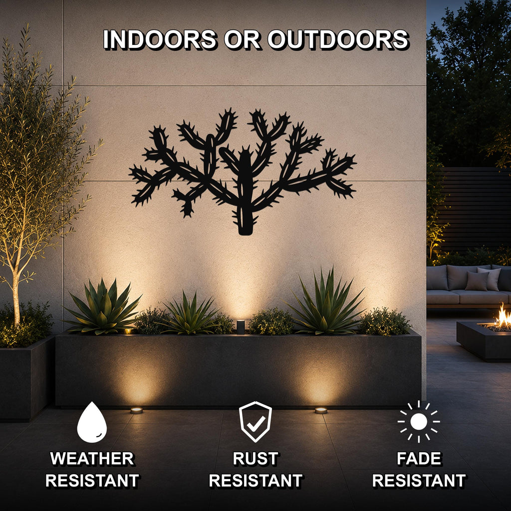 Black metal Cholla cactus wall art with a detailed spine cutout, mounted on an outdoor wall above a planter in a modern patio setting.