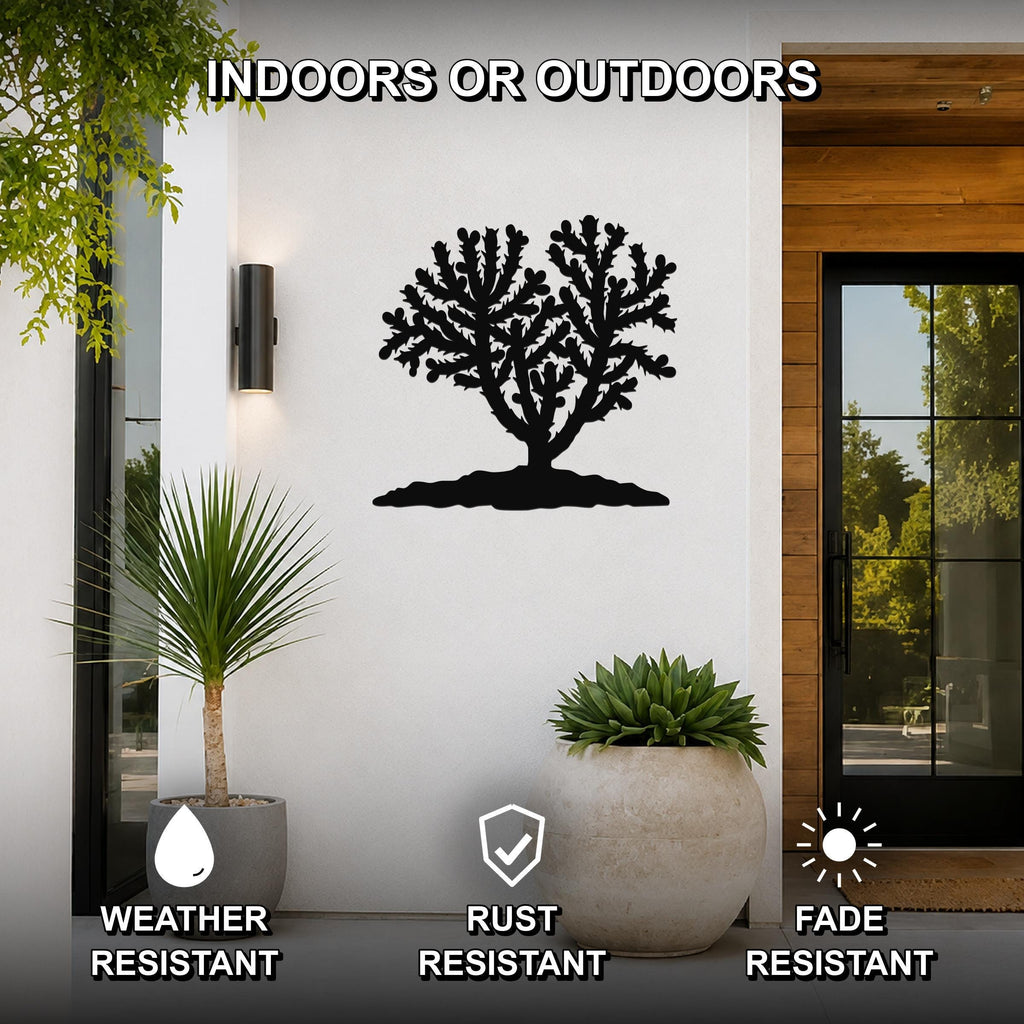 Black metal Cholla cactus wall art with detailed branch cutouts, mounted on a white exterior wall beside a glass door and potted plants.