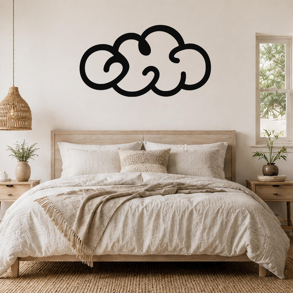 Black metal cloud wall art with a bold silhouette design, mounted above a wooden bed in a neutral-toned bedroom.
