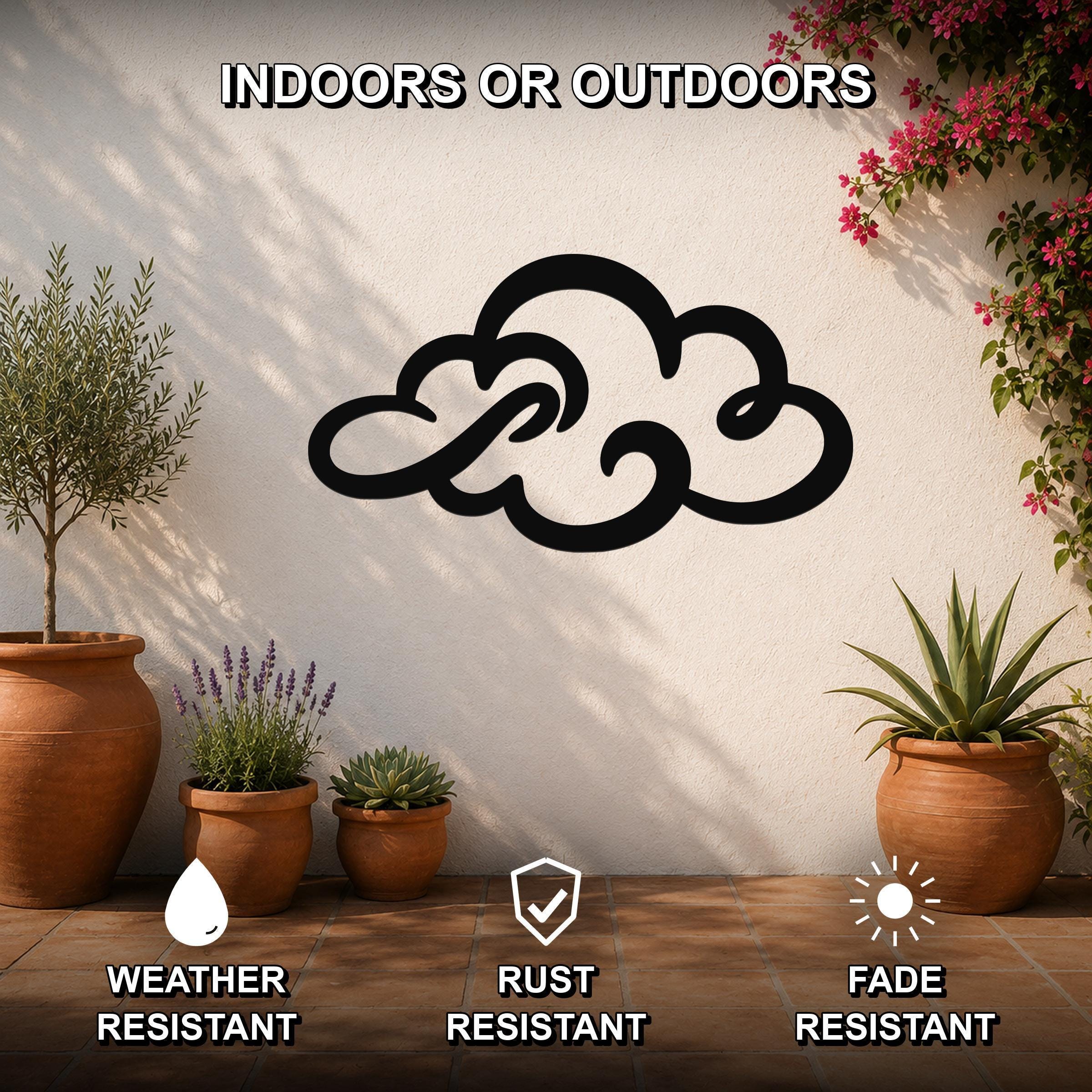 Black metal cloud wall art with swirling cutout design, mounted on a white outdoor wall above potted plants on a tiled patio.