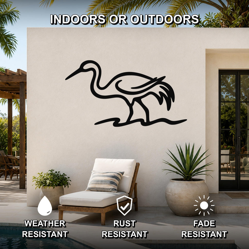 Black metal crane wall art with a minimalist silhouette design, mounted on an outdoor patio wall above a lounge chair.