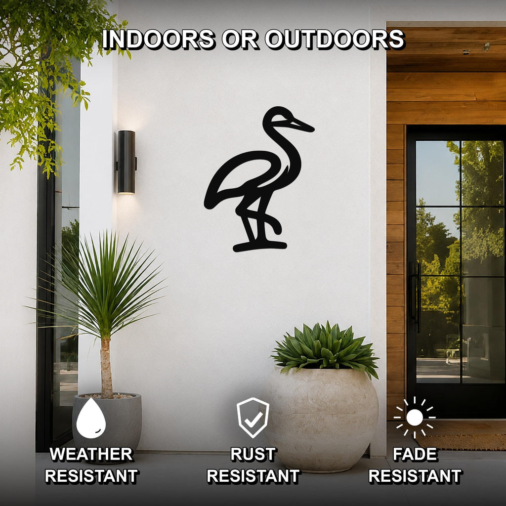 Black metal crane wall art silhouette mounted on a white exterior wall beside a glass door, with potted plants nearby and text indicating it is weather, rust, and fade resistant for indoor or outdoor use.