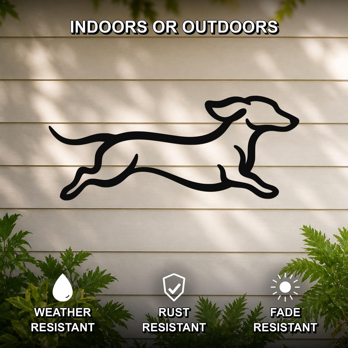 Black metal dachshund wall art with motion-line cutouts, mounted on a light-colored outdoor wall with greenery below.
