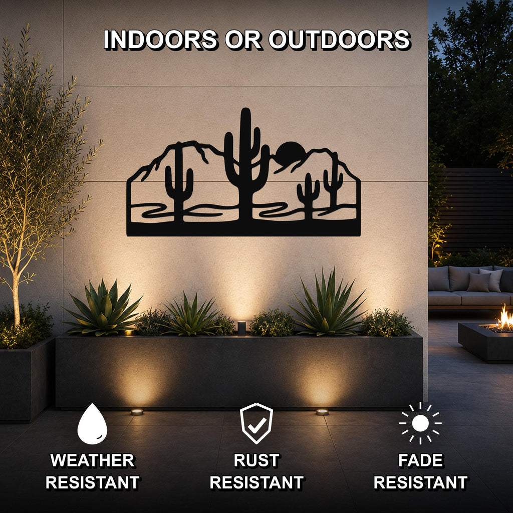 Black metal wall art with a desert silhouette of saguaro cacti and mountains, mounted on an outdoor wall above a planter in a patio setting.