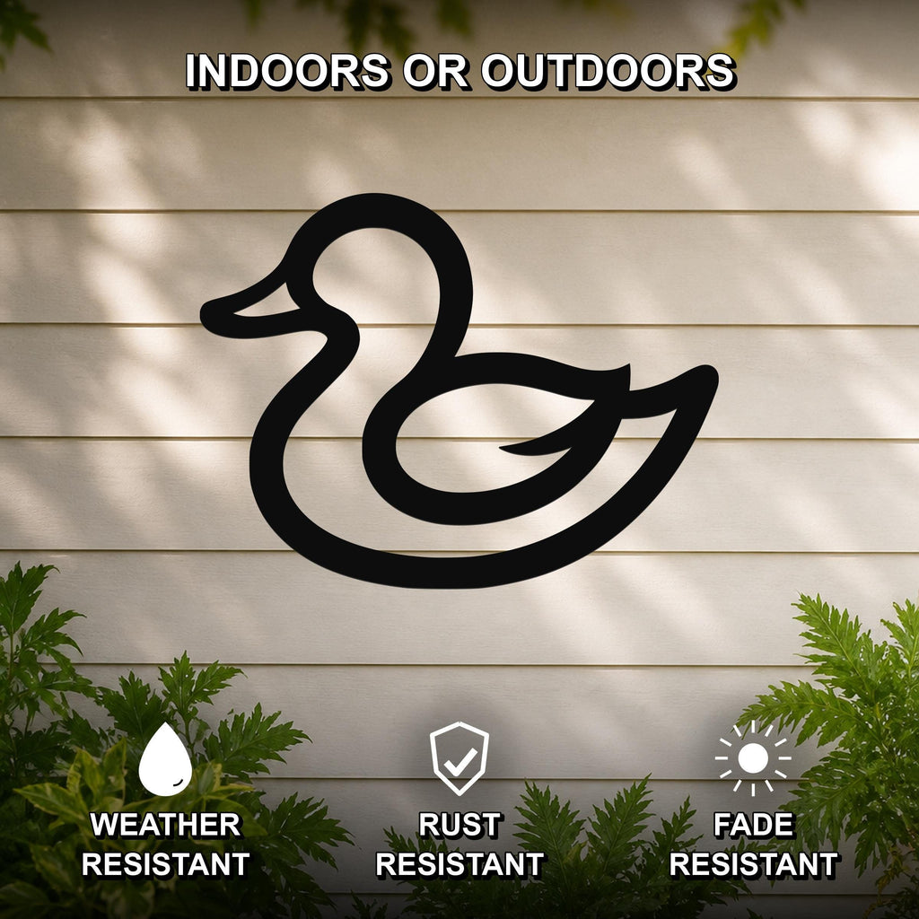 Black metal duck silhouette wall art mounted on a light-colored outdoor wall, featuring weather, rust, and fade resistance with green foliage visible below.