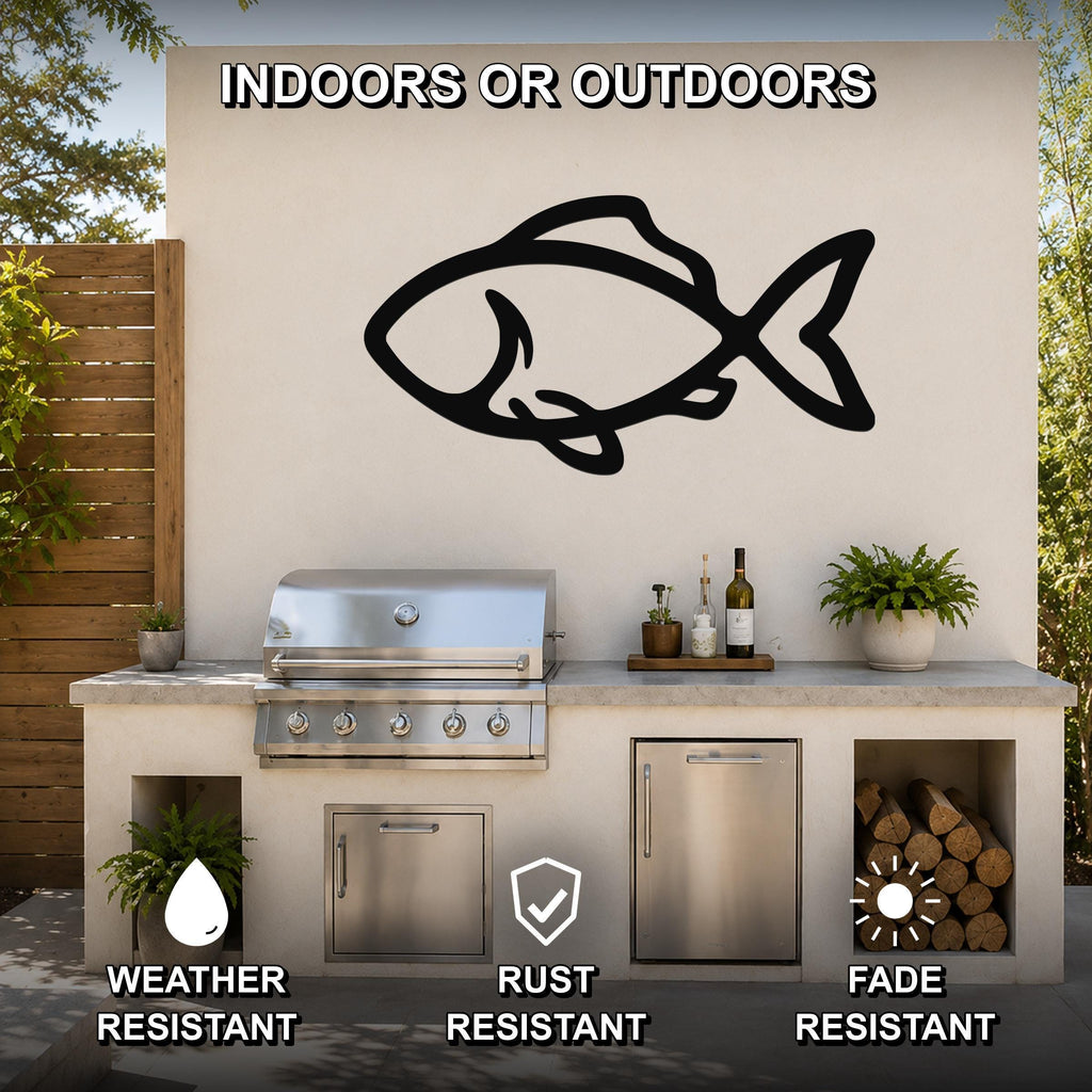 Black metal fish silhouette wall art mounted on an outdoor patio wall above a stainless steel grill and countertop, with visible weather, rust, and fade resistance icons.