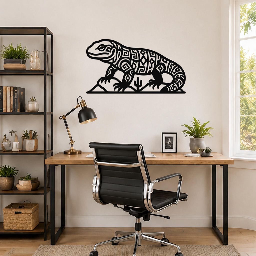 Black metal wall art of a Gila monster with intricate geometric cutouts, mounted above a wooden desk in a home office.