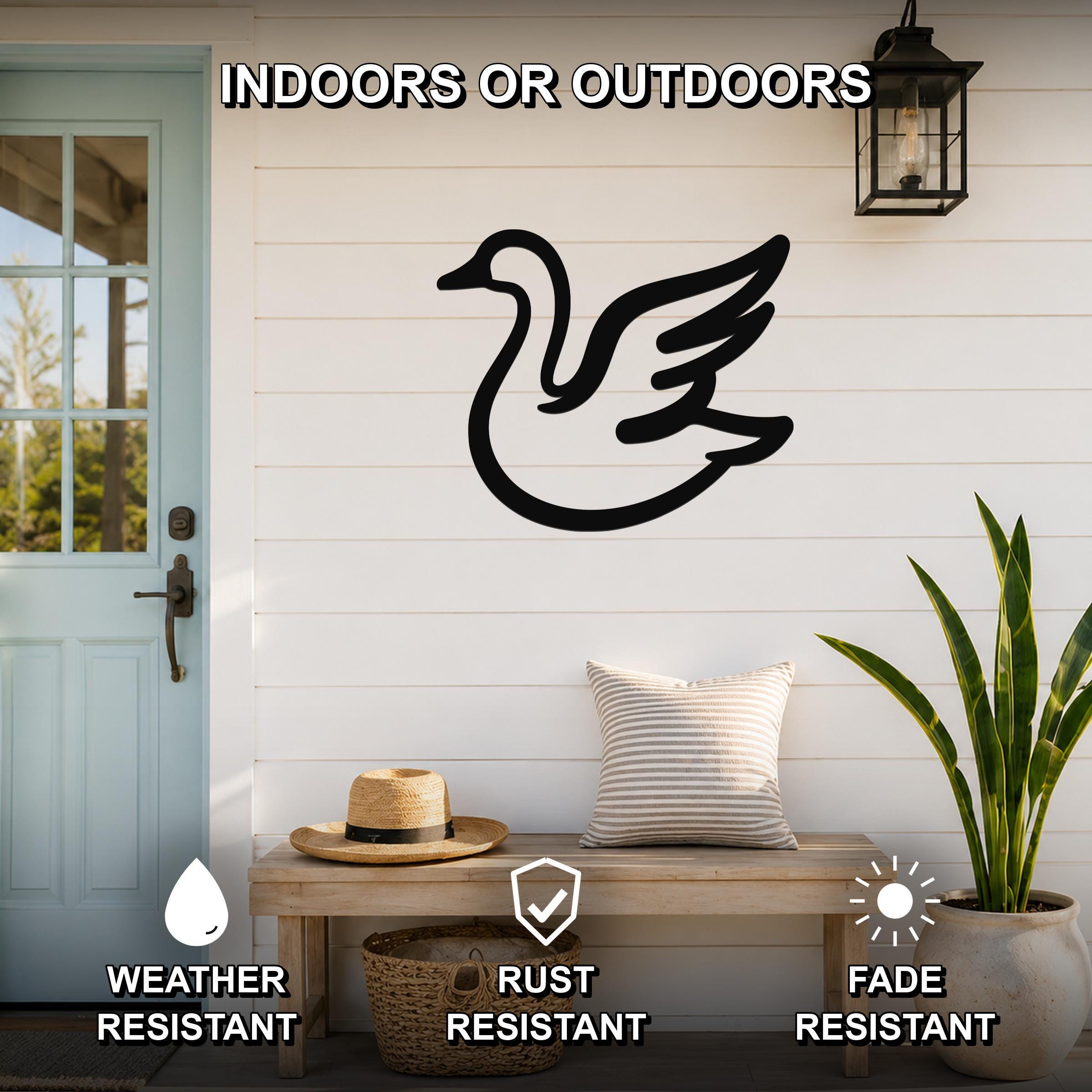 Black metal goose wall art silhouette mounted on a white shiplap wall above a wooden bench on a porch, with text indicating it is weather, rust, and fade resistant.