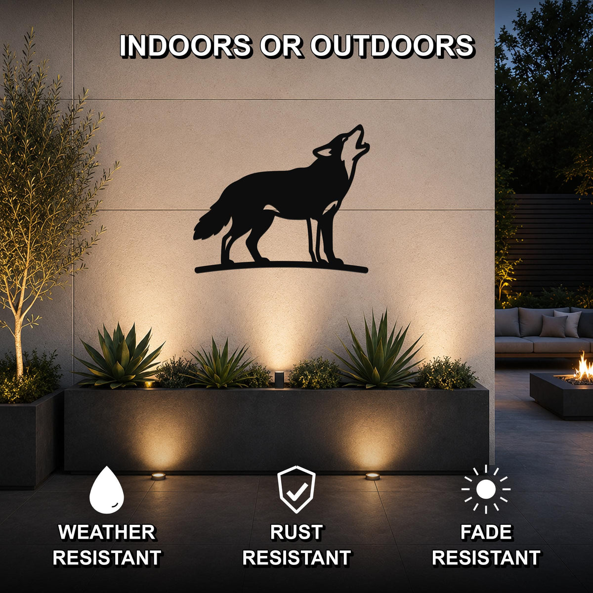 Black metal coyote wall art in a howling silhouette, mounted on an outdoor wall above a planter with uplighting, featuring weather, rust, and fade resistance.