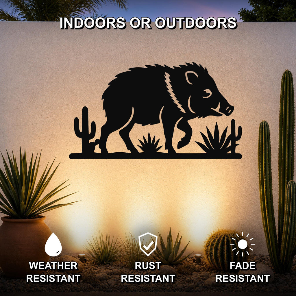 Black metal javelina wall art with cactus and agave cutouts, mounted on an outdoor wall in a desert-themed garden setting.
