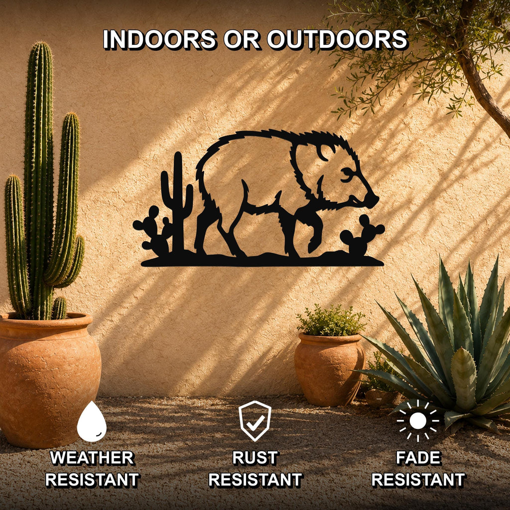 Black metal javelina wall art silhouette with cactus cutouts, mounted on a stucco outdoor wall among potted desert plants.