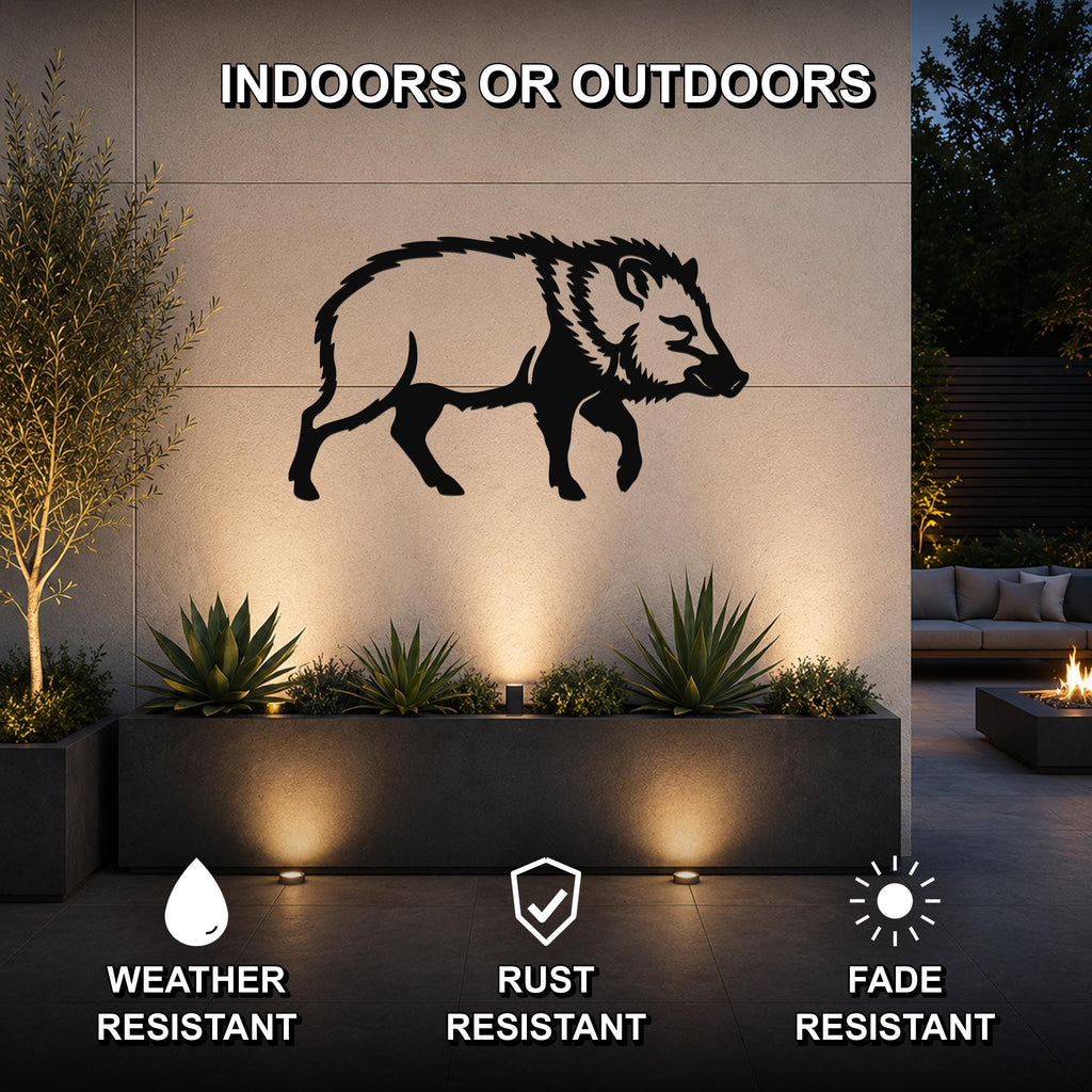 Black metal javelina wall art silhouette mounted on an outdoor wall above a planter, illuminated by uplights in a modern patio setting.
